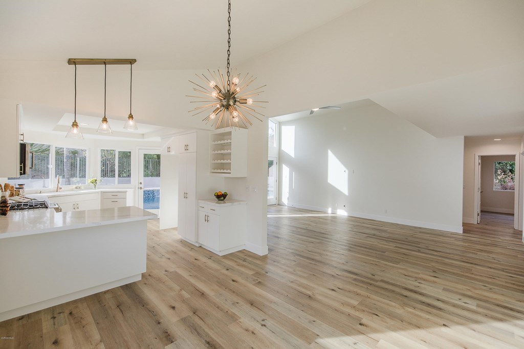 Open plan living and dining area in Los Angeles after an interior remodel, with white walls and wide plank flooring