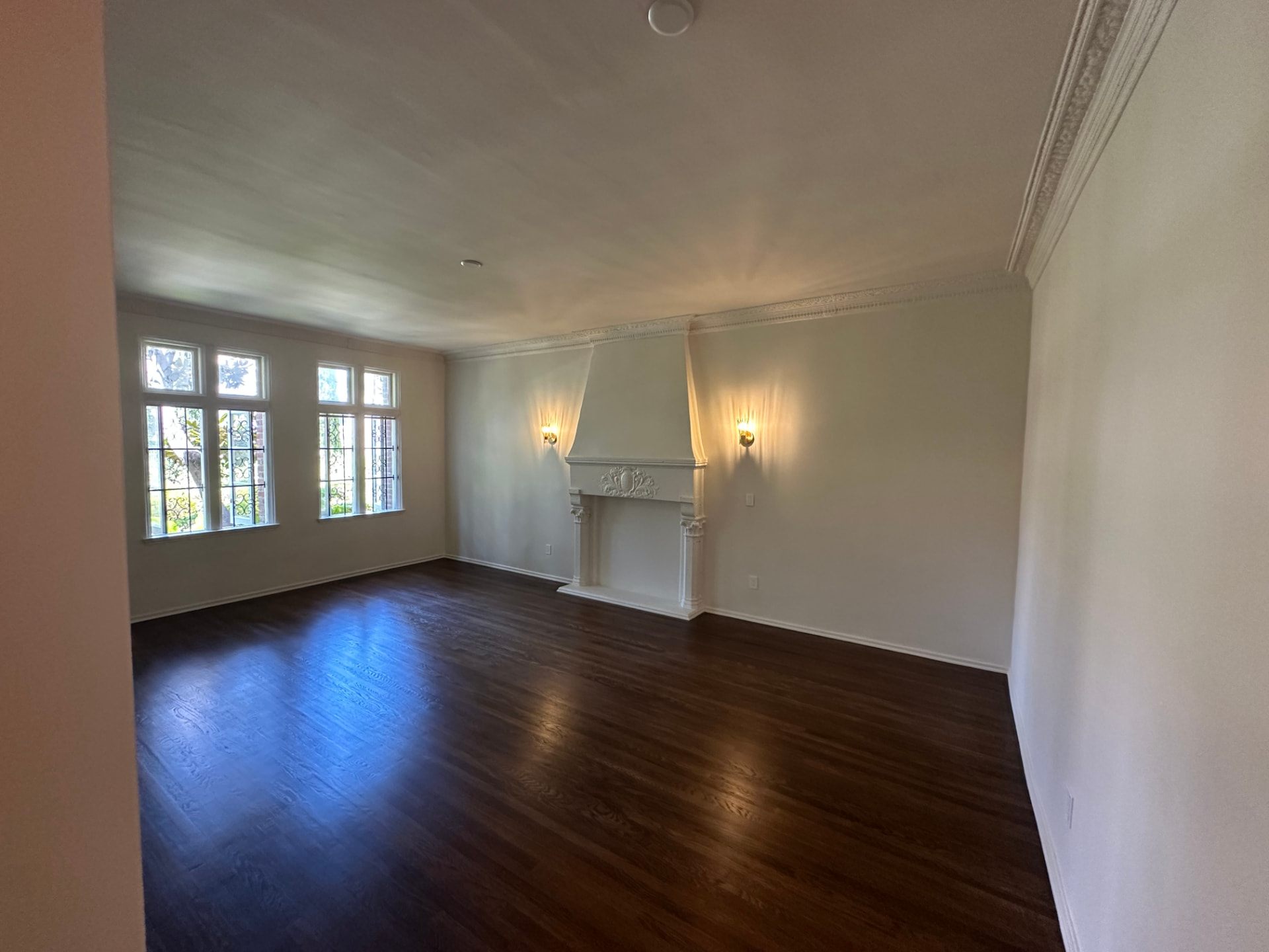 Formal room in Beverly Hills with repaired plaster walls, detailed crown molding, leaded glass windows, and refinished hardwood flooring