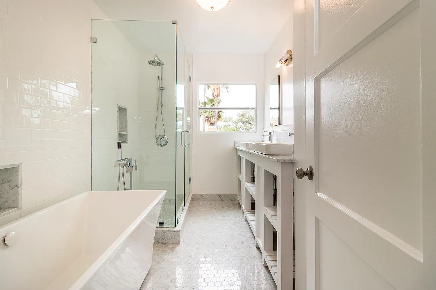 Renovated Los Angeles bathroom with a freestanding tub, white finishes, and modern fixtures near a window